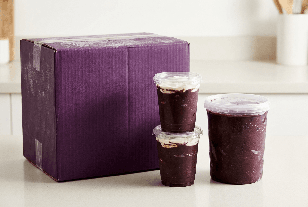 Caixa de açaí de 10 litros da fábrica ao lado de um pote de açaí de 3 litros de varejo, com copos de 500ml mostrando o rendimento de cada formato