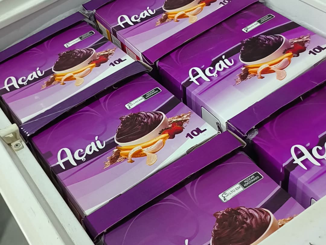 Freezer da fábrica Algo Mais lotado de caixas de açaí de 10 litros empilhadas, prontas para sair em rota